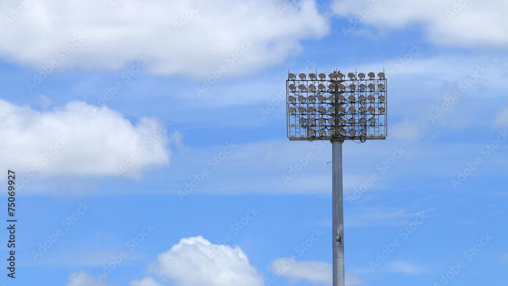 Stadium spot lights, beautiful blue sky and clouds running. Stadium spot lights, beautiful blue sky and clouds running.