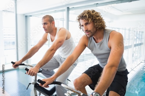 Men working on exercise bikes at gym
