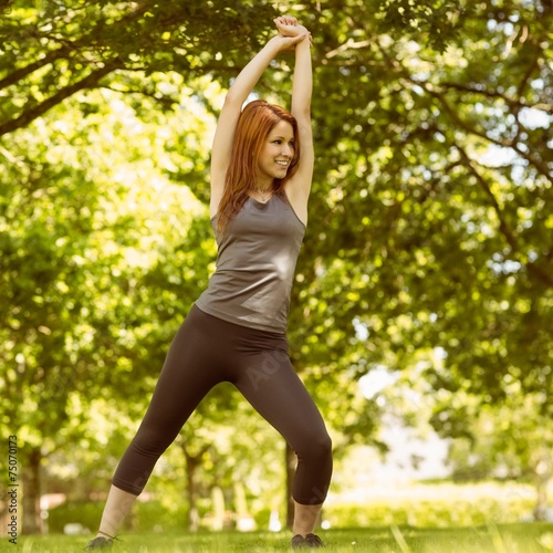 Pretty athletic redhead stretching in park © WavebreakMediaMicro