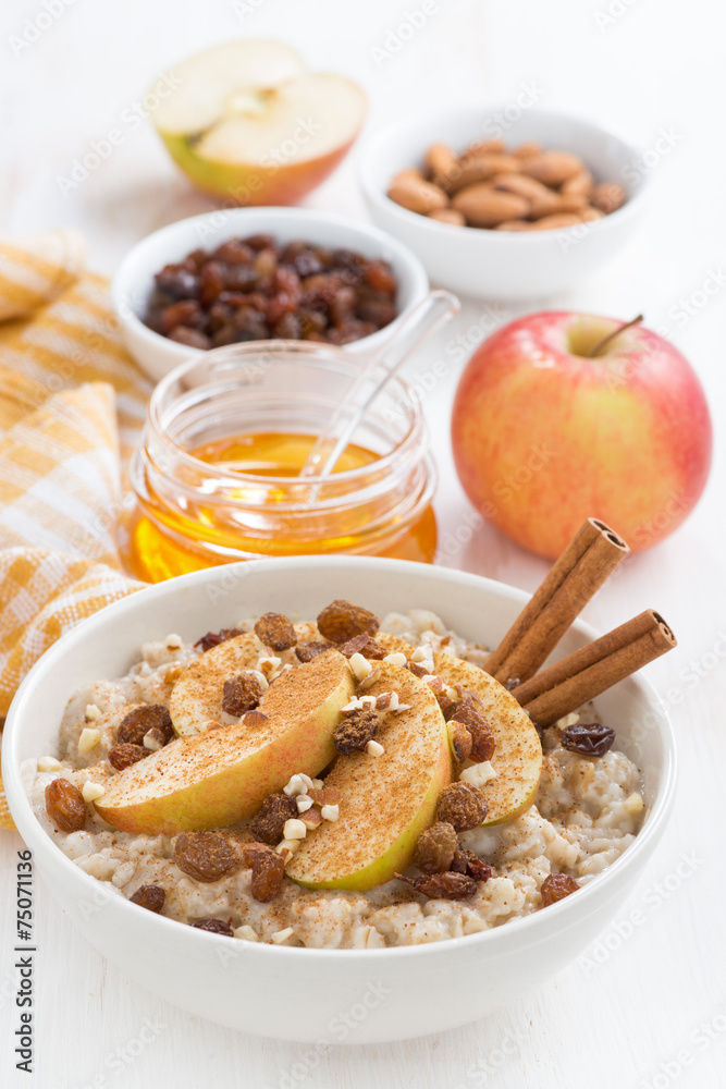 oatmeal with apples, raisins, cinnamon and ingredients on white oatmeal with apples, raisins, cinnamon and ingredients on white