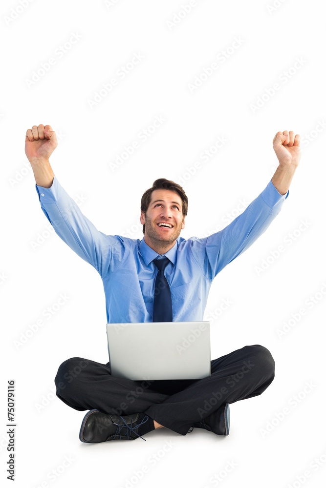 Businessman cheering with laptop sitting on floor Businessman cheering with laptop sitting on floor