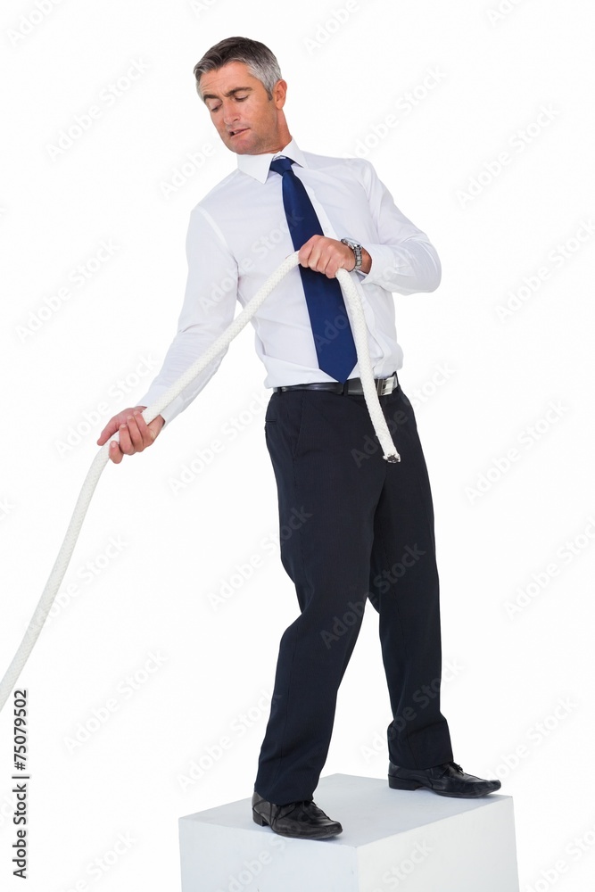 Businessman standing on a cube and pulling rope Businessman standing on a cube and pulling rope