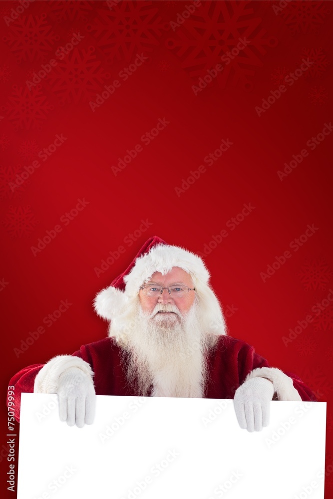 Naklejka premium Composite image of santa is holding a sign