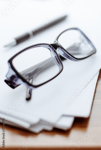 Glasses and pen on white paper for notes