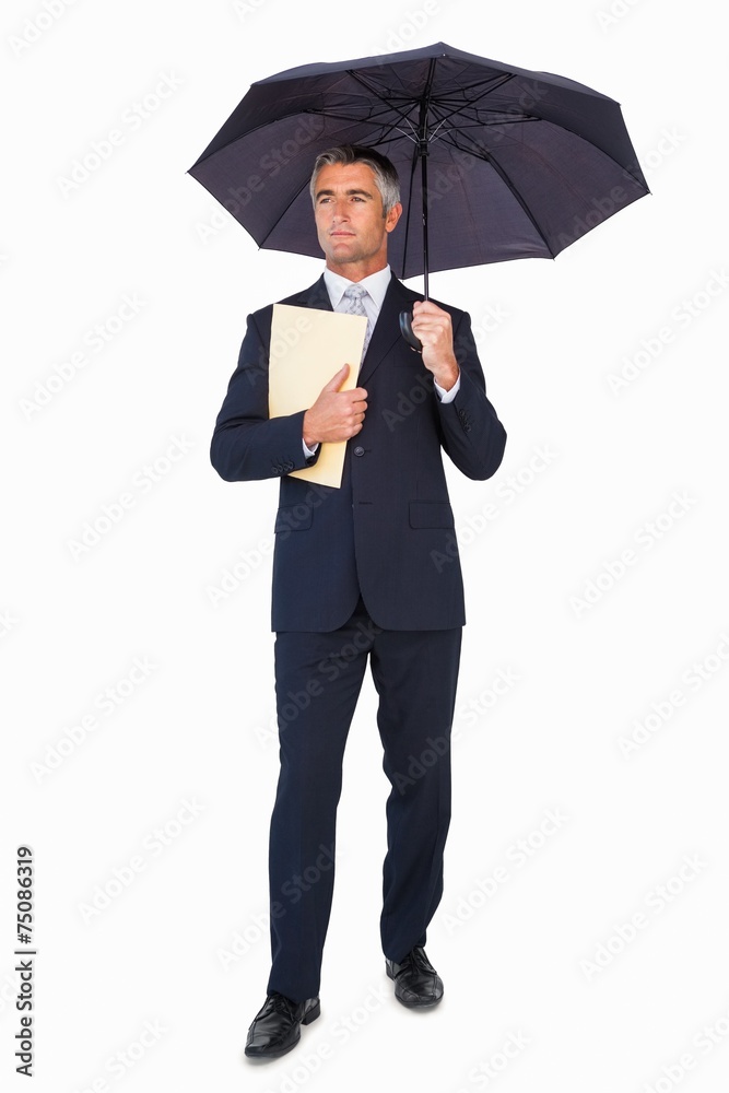 Businessman holding file under umbrella Businessman holding file under umbrella