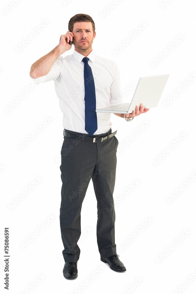 Businessman on the phone holding laptop Businessman on the phone holding laptop