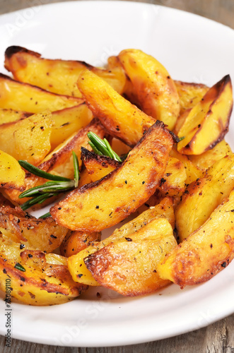 Fried potato wedges on white plate