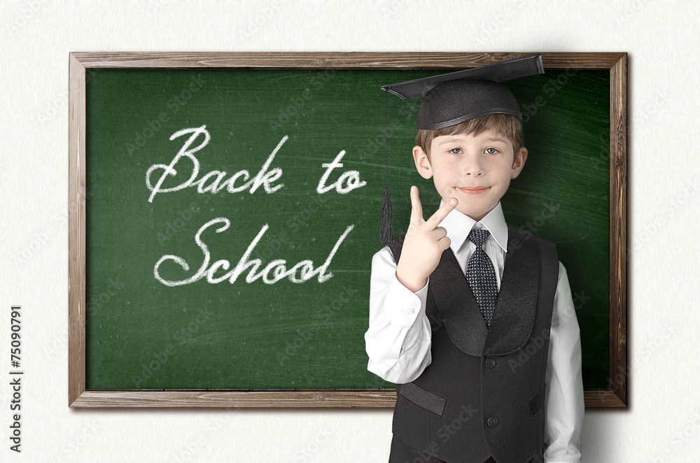 Cheerful little boy on blackboard. Looking at camera Cheerful little boy on blackboard. Looking at camera