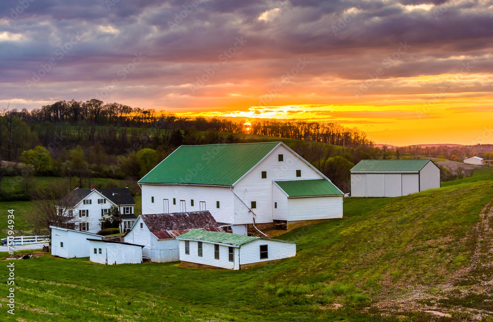 Sunset over a barn and farm fields in rural York County, Pennsyl