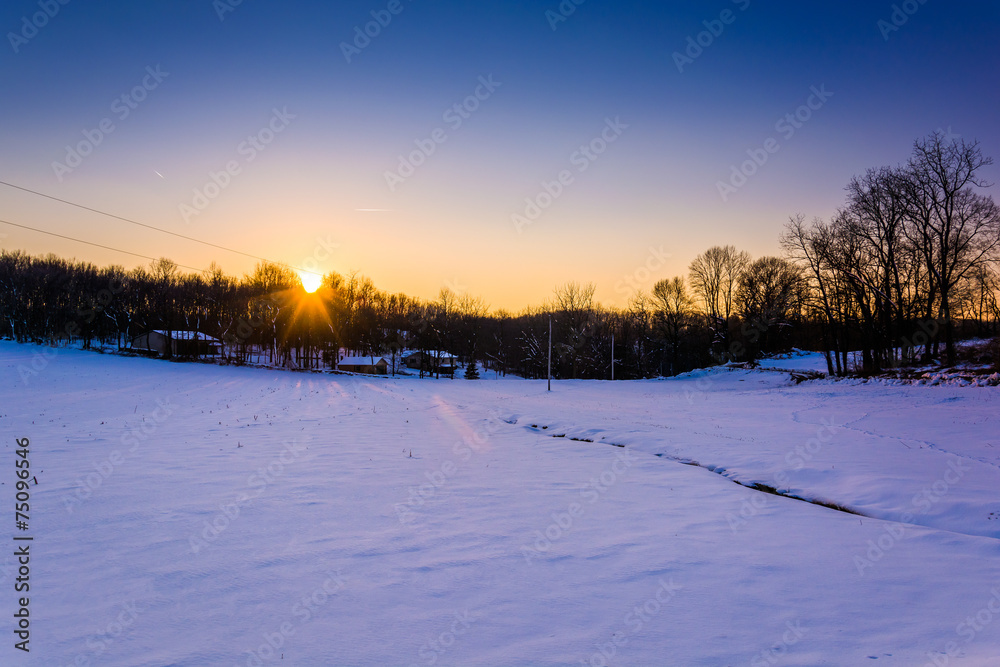Sunset over a snow-covered farm field in rural York County, Penn Sunset over a snow-covered farm field in rural York County, Penn