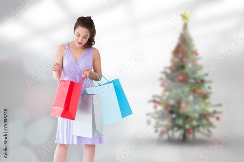 Stylish brunette in purpul dress opening shopping bag