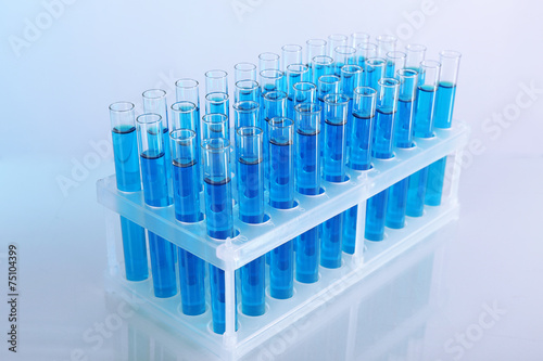 Blue water in a transparent test-tube on light background