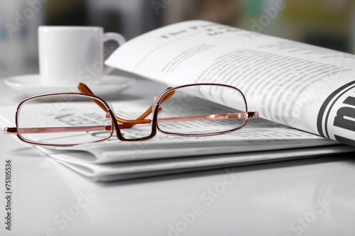Картината върху платно Glasses and newspapers, close-up