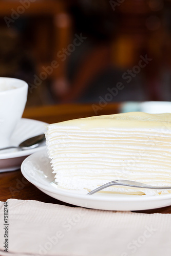 White cake on white dish with fork, napkin on table