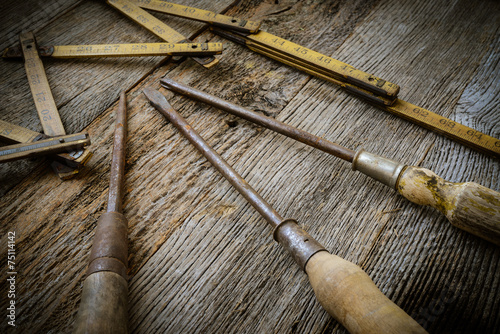 Old Tape Measure and Screwdriver for Construction on Rustic Wood