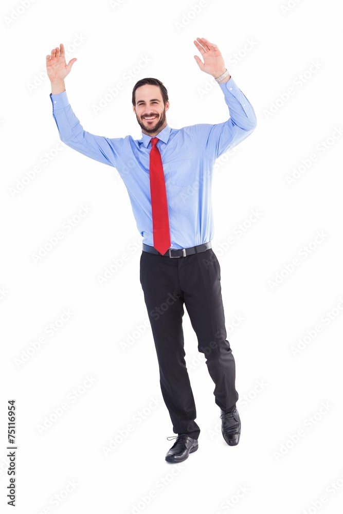 Smiling businessman stepping with hands raised