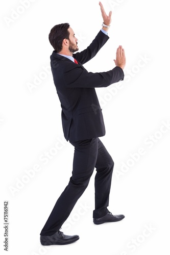 Businessman standing and pushing up