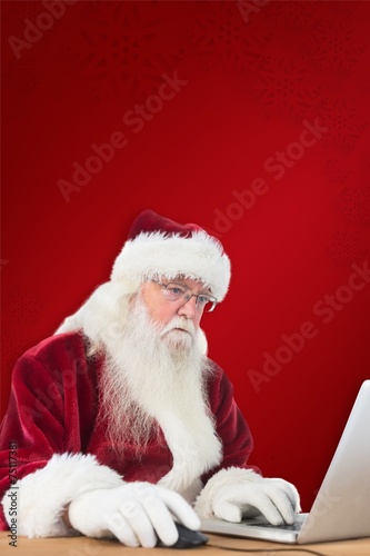 Composite image of santa surfs on the internet photo