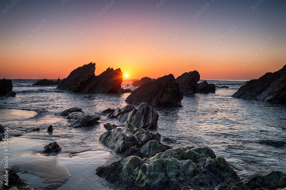 Sunset over rocks on Sharrow beach