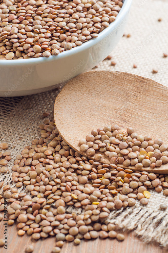 Organic lentils with wooden false on burlap background Organic lentils with wooden false on burlap background