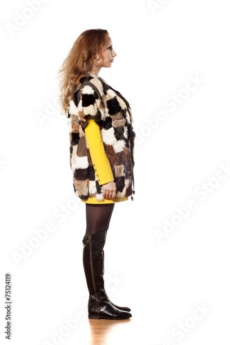 side view young woman in a short fur coat without sleeves