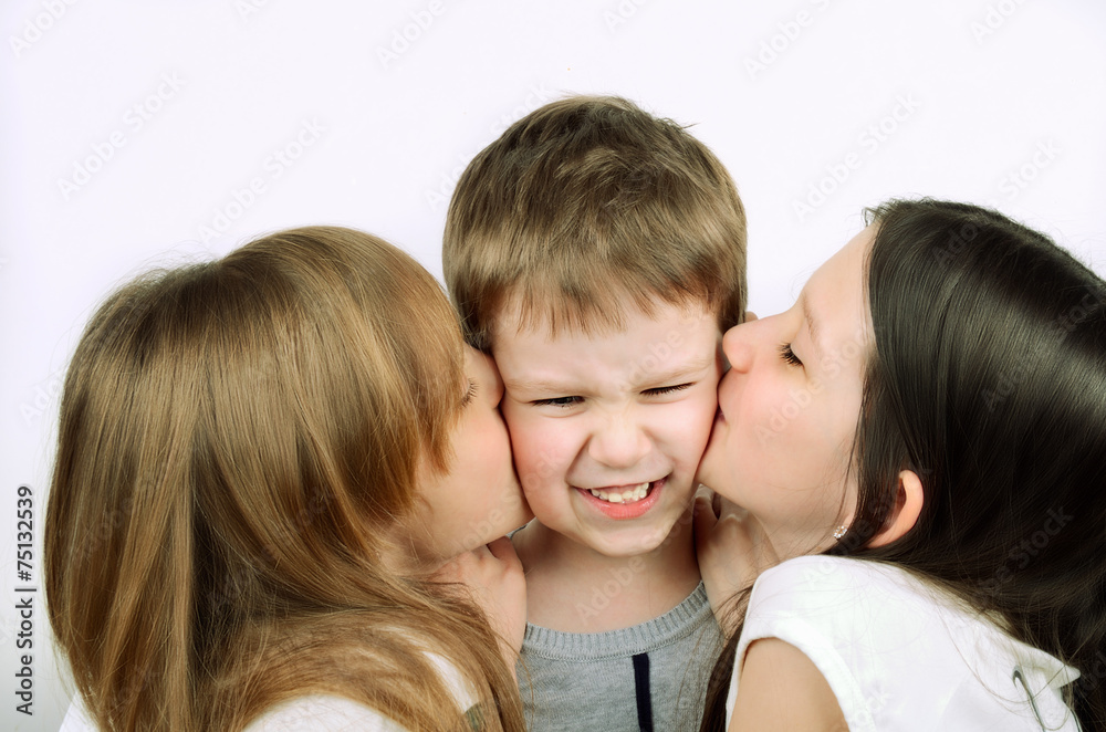 two girls kissing little angry boy on the light background two girls kissing little angry boy on the light background