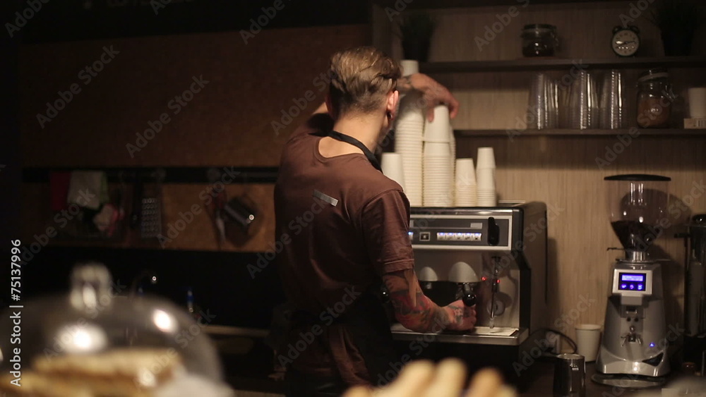 Worker of coffee shop making coffee for guests Worker of coffee shop making coffee for guests