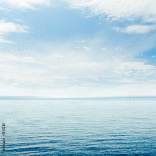 blue sea and cloudy sky over it