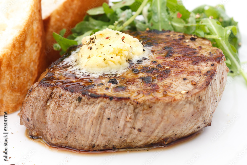 Roast pork tenderloin fillet steak topped with melting butter.
