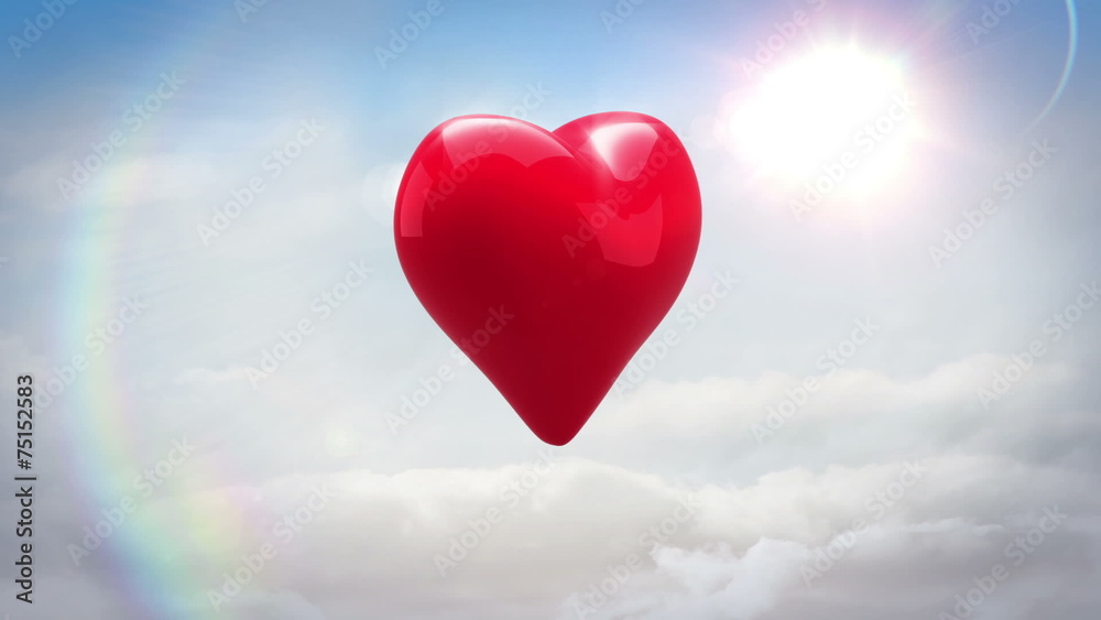 Red heart turning and exploding over blue sky Red heart turning and exploding over blue sky