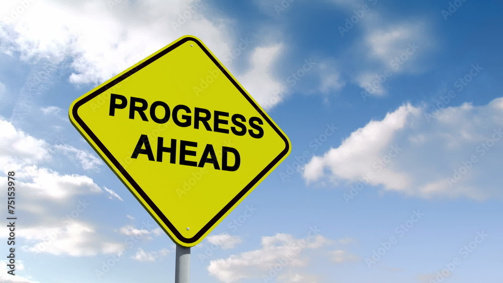 Progress ahead sign against blue sky Progress ahead sign against blue sky