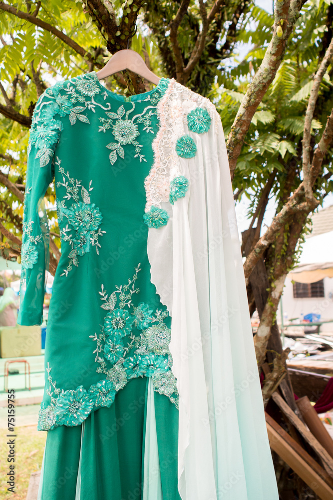 Green Malay Wedding Dress hanging on tree
