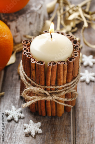 Candle decorated with cinnamon sticks, christmas decoration