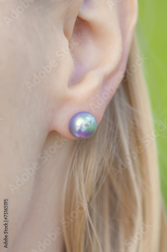 woman's ear with a pearl earring