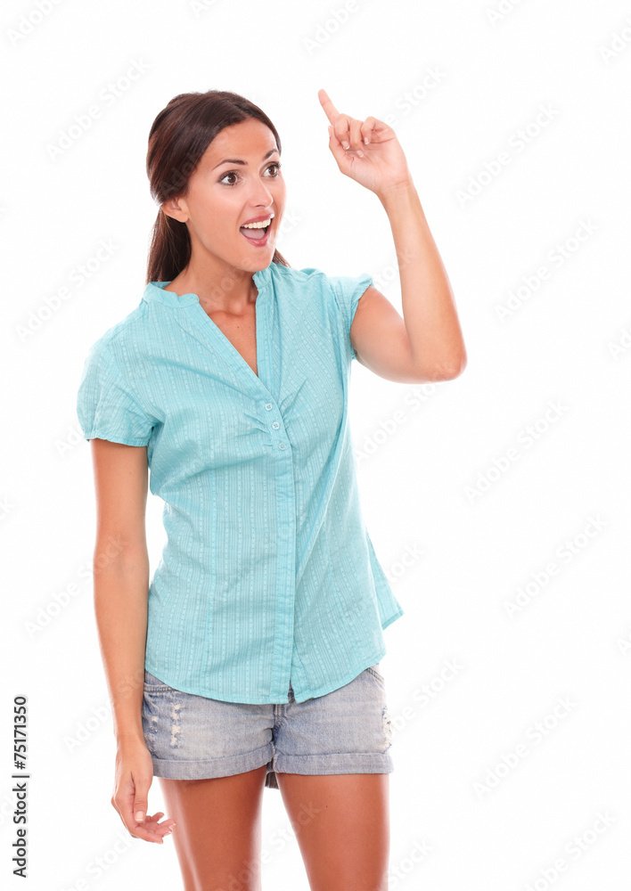 Surprised woman in short jeans pointing up