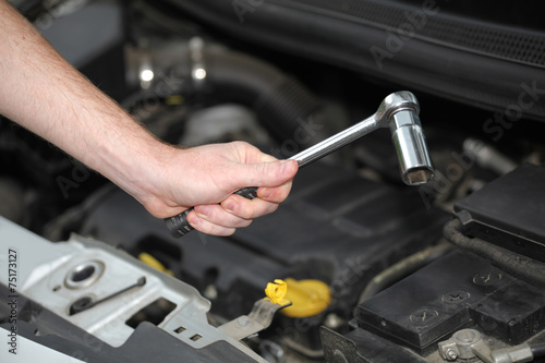 Auto mechanic with chrome plated wrench in closeup