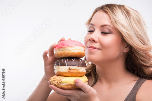 Young attractive woman with doughnuts isolated on white backgrou