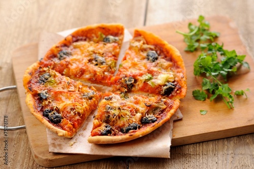 Pizza with olives and salmon and fresh greens