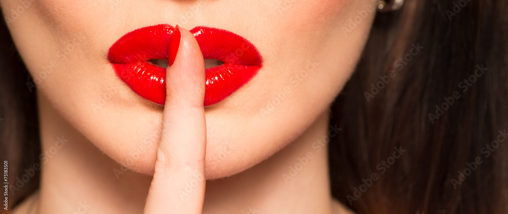 Fototapeta premium makro ust z czerwonym palcem szminki pokazujący ciszy i ciszy