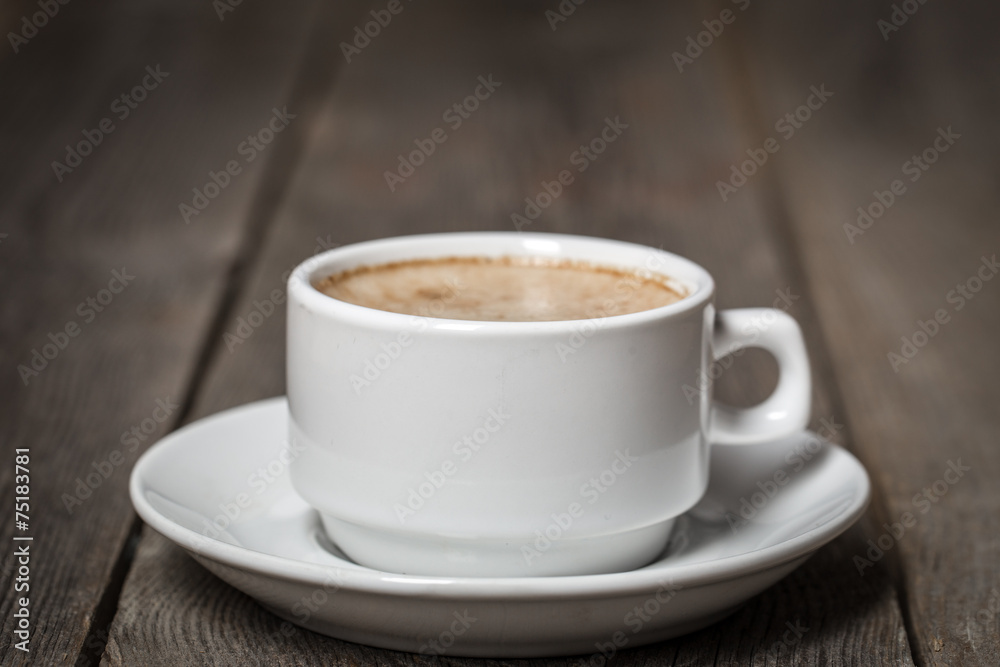 White mug with coffee standing on wooden table. White mug with coffee standing on wooden table.