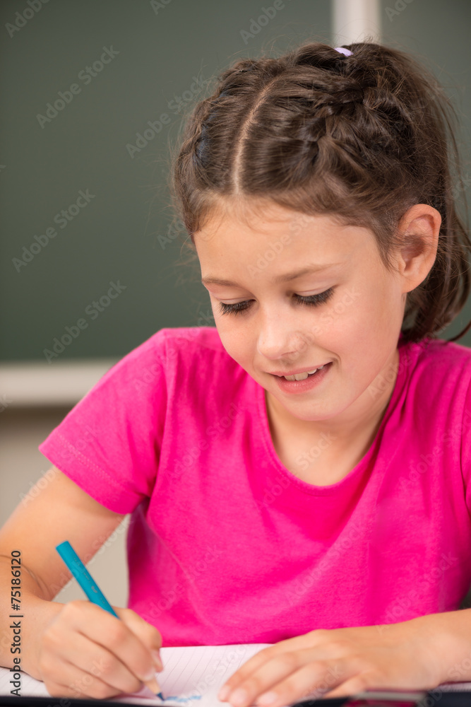 Mädchen schreibt in der Grundschule Mädchen schreibt in der Grundschule