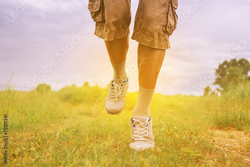 Man running on footpath in summer sunny day