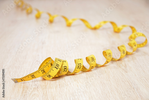 Measure tape on wooden background