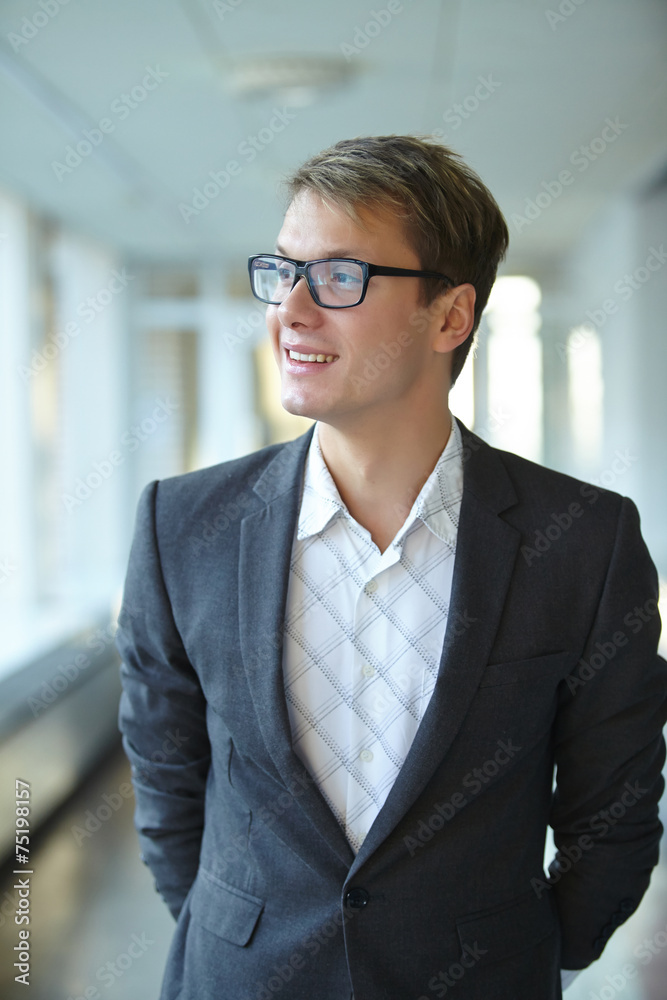 young businessman with glasses standing in the hallway young businessman with glasses standing in the hallway
