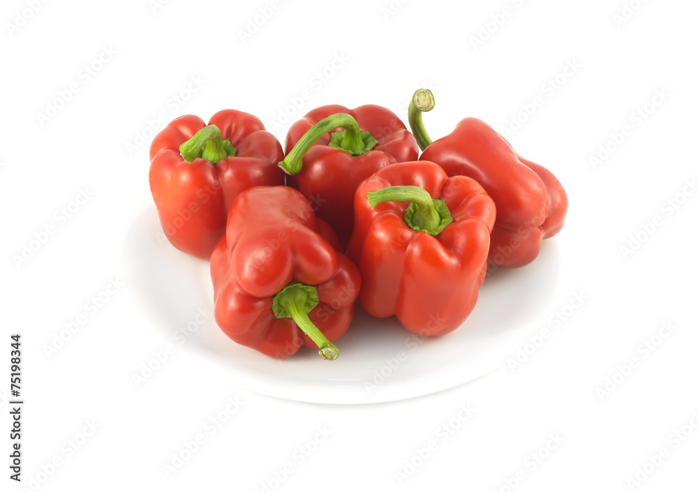 Five whole red ripe bell peppers isolated on white closeup