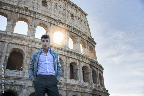 Photography Handsome young man in Rome standing in front of the Colosseum