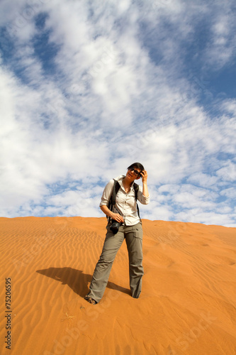 Woman tourist climbing a sand dune © Morenovel
