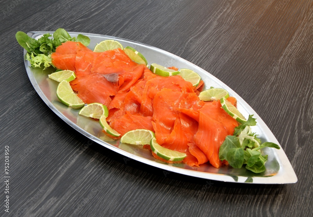 plat de saumon fumé en tranches,décor citron vert Photos | Adobe Stock
