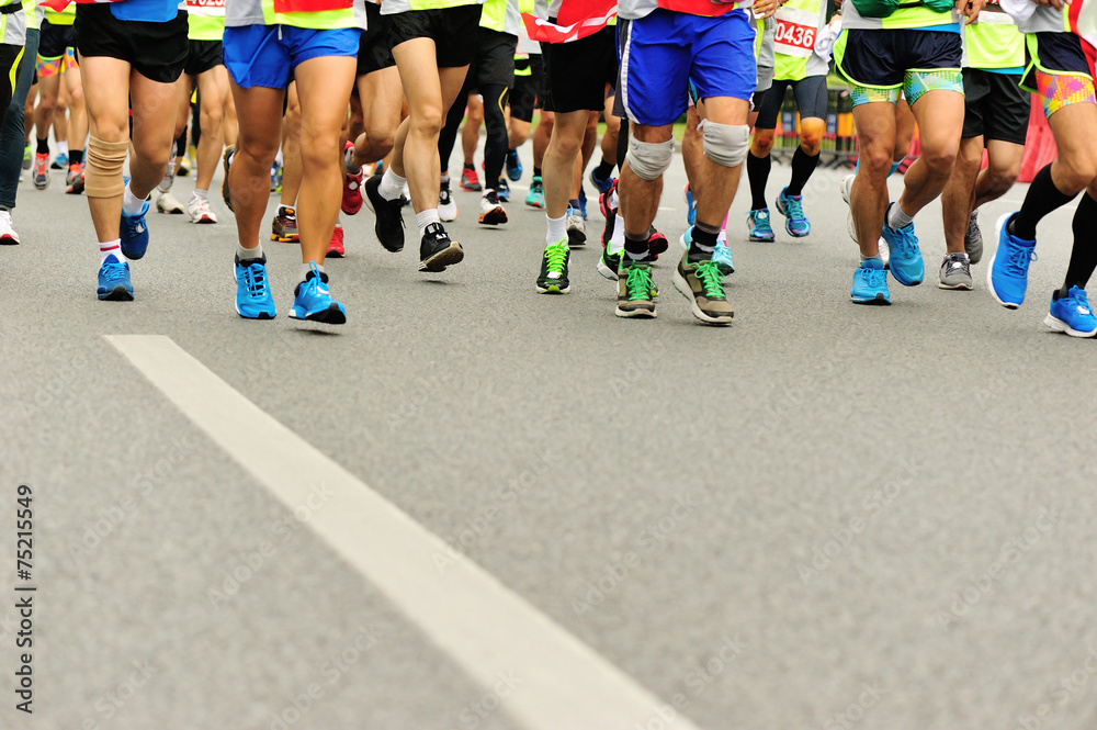 marathon athletes legs running on city road