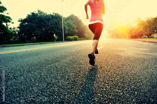 woman runner running at sunrise road 